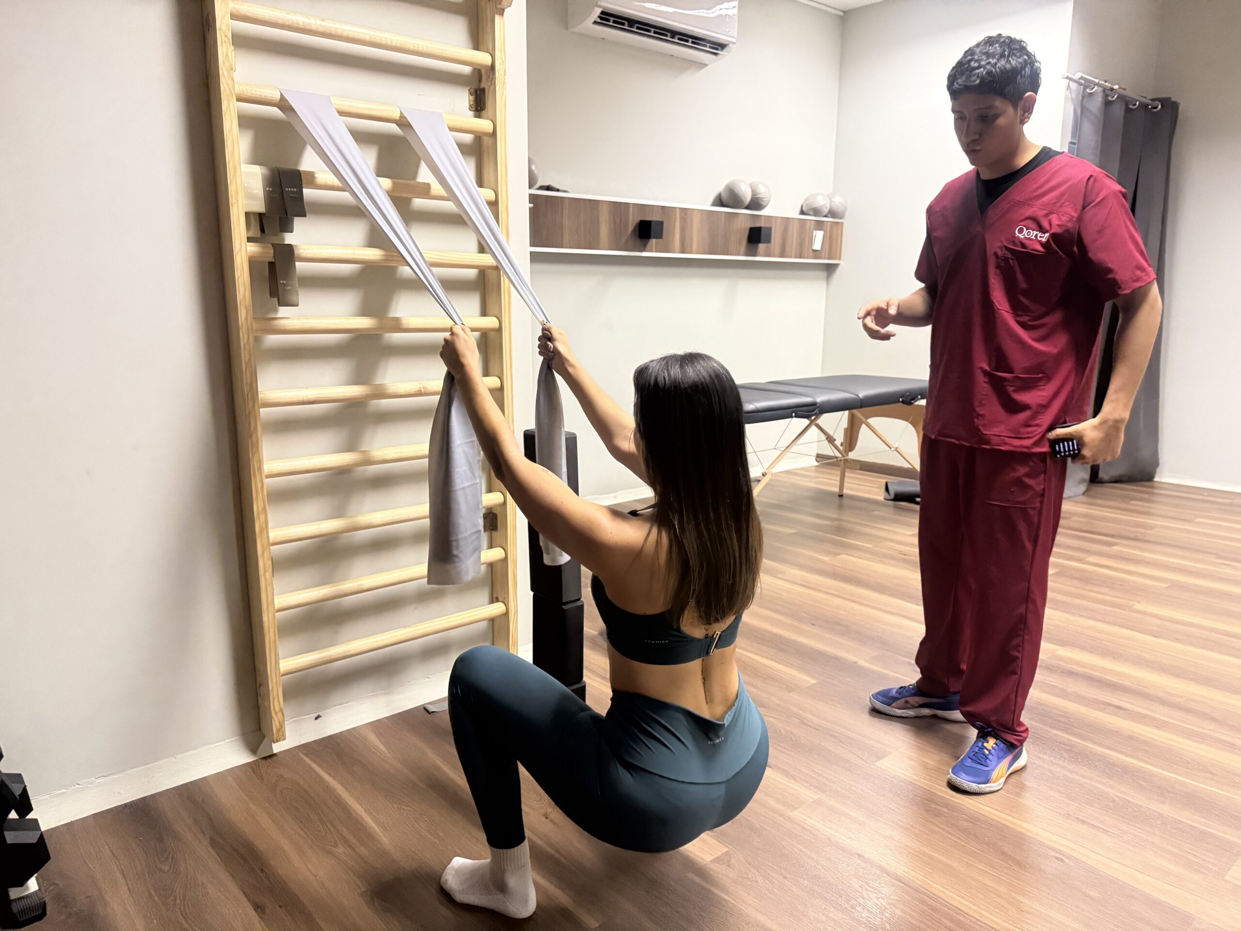 Ejercicio de sentadilla asistida con escalera sueca en Qoren